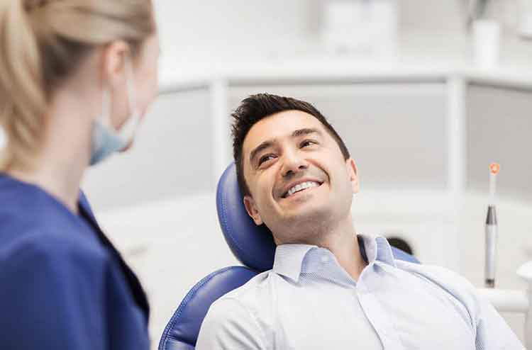 A Smiling Man Seated in a Dental Chair Representing Restorative Dentistry Services in Parker, CO. A Smiling Man Seated in a Dental Chair Representing Restorative Dentistry Services in Parker, CO.