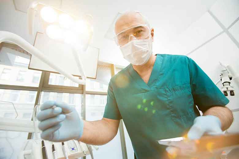 Dentist handing the tooth removal instrument