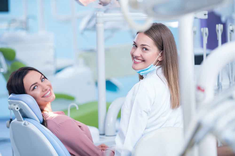Dentist standing and patient laying on the chair.