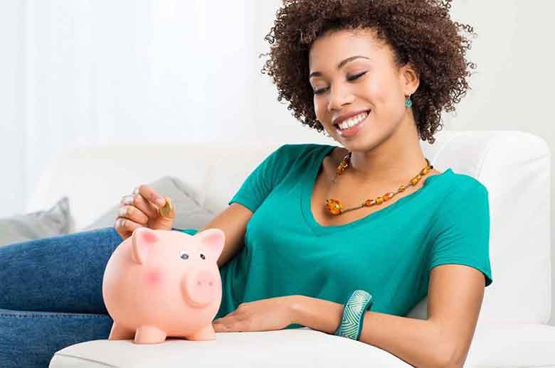 Women inserting coin in the piggy bank