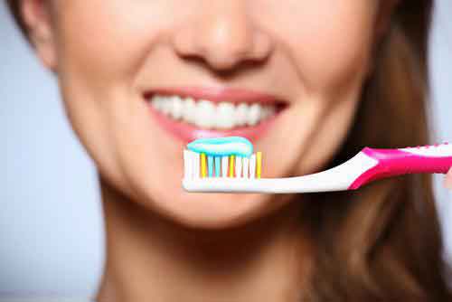 Smiling Women with toothbrush in her hand close to the teeth