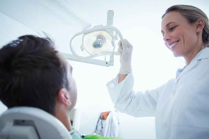 Women Dentist checking her patient using dentist machine