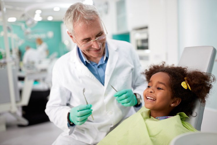 Happy Child on dental appointment after repairing tooth