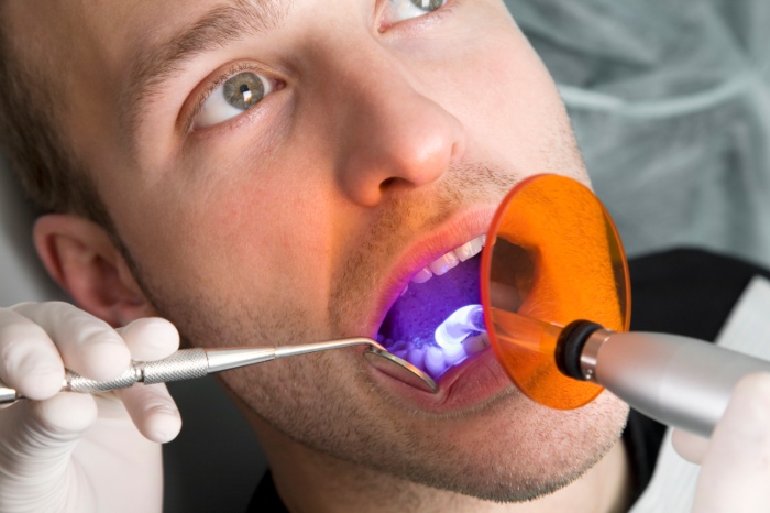 Male patient during a dental treatment. Close-up.